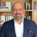 Emre Başkan Kameraya hafif bir şekilde gülümsüyor.