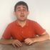 Süleyman is looking at the camera and speaking.