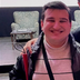 Serdar is looking to the camera, smiling and giving a speech